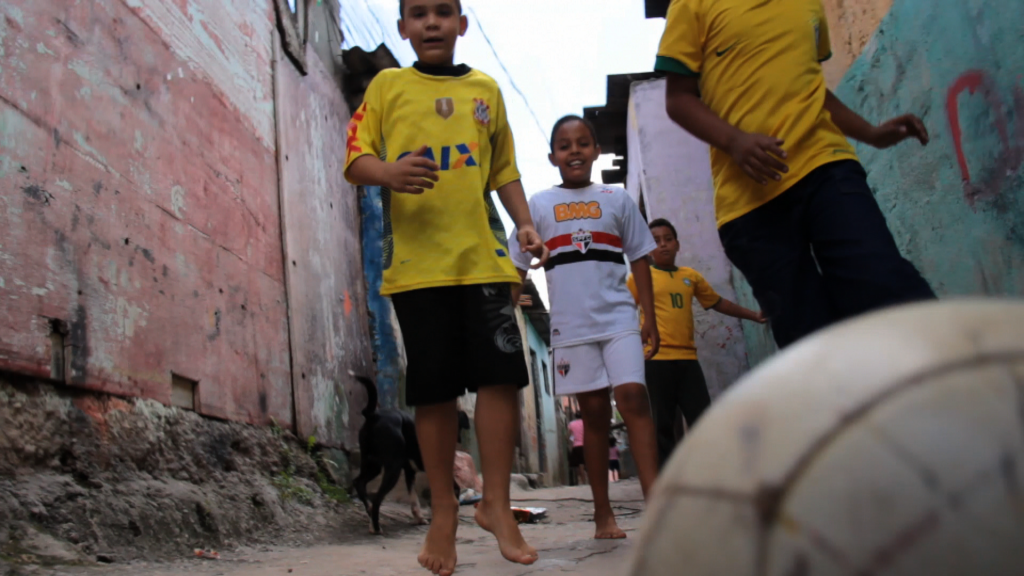 Buben in einer Gasse mit einem Fussball