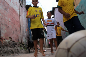 Buben in einer Gasse mit einem Fussball