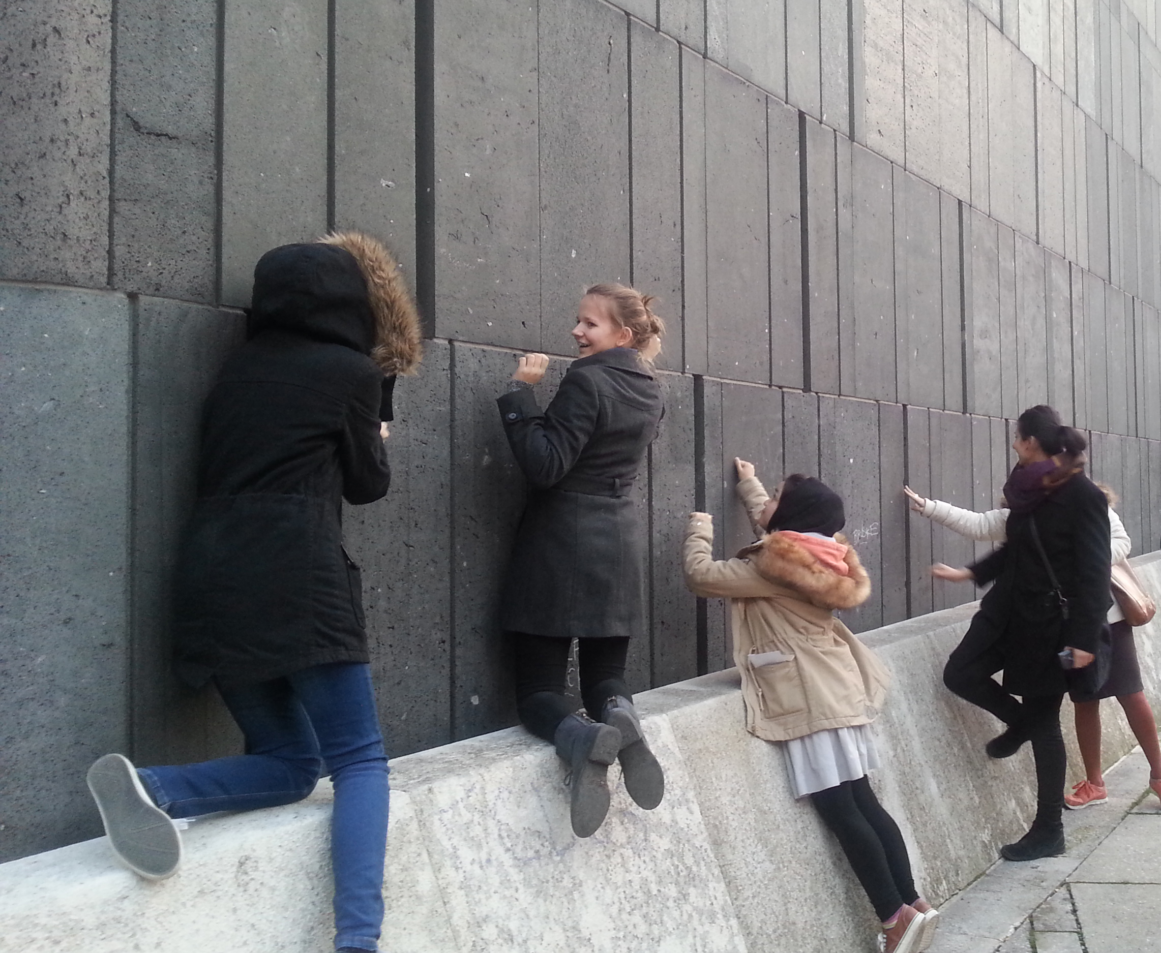 Vier Personen an die Fassade eines Museums klopfend