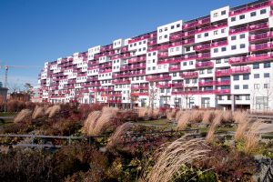 Ein langgestreckter Wohnbau mit pinkfarbenen Balkonen