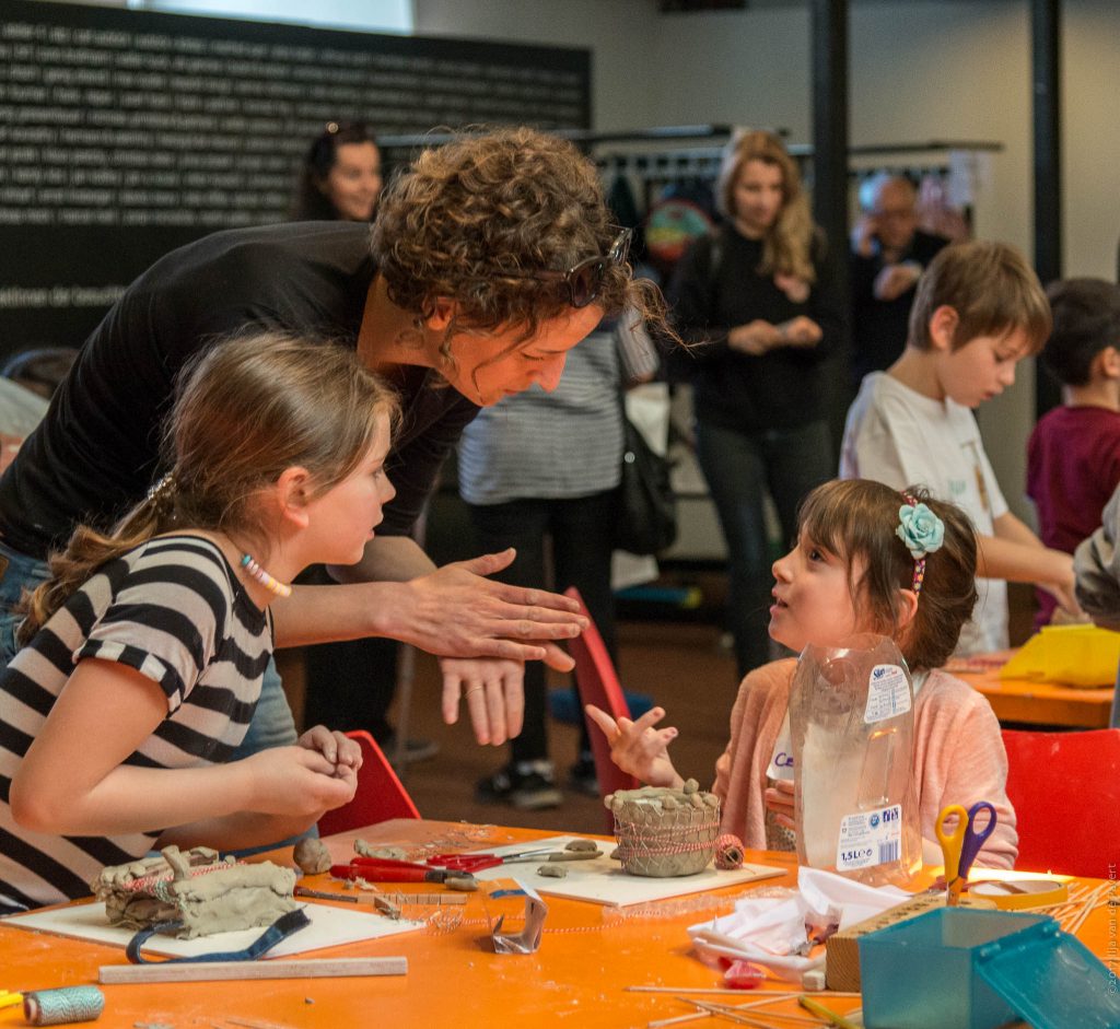 Eine Vermittlerin mit zwei Kindern beim Workshop