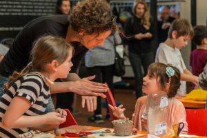 Eine Vermittlerin mit zwei Kindern beim Workshop