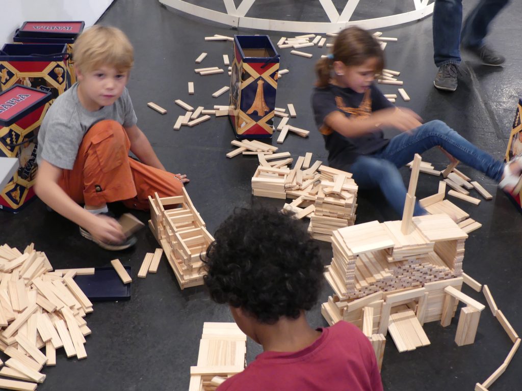 Drei Kinder bauen mit Kaplasteinen ein Modell