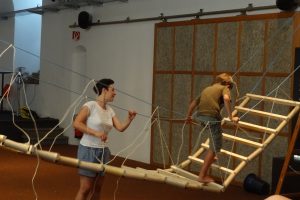 Ein Kind geht über eine selbstgebaute Hängebrücke