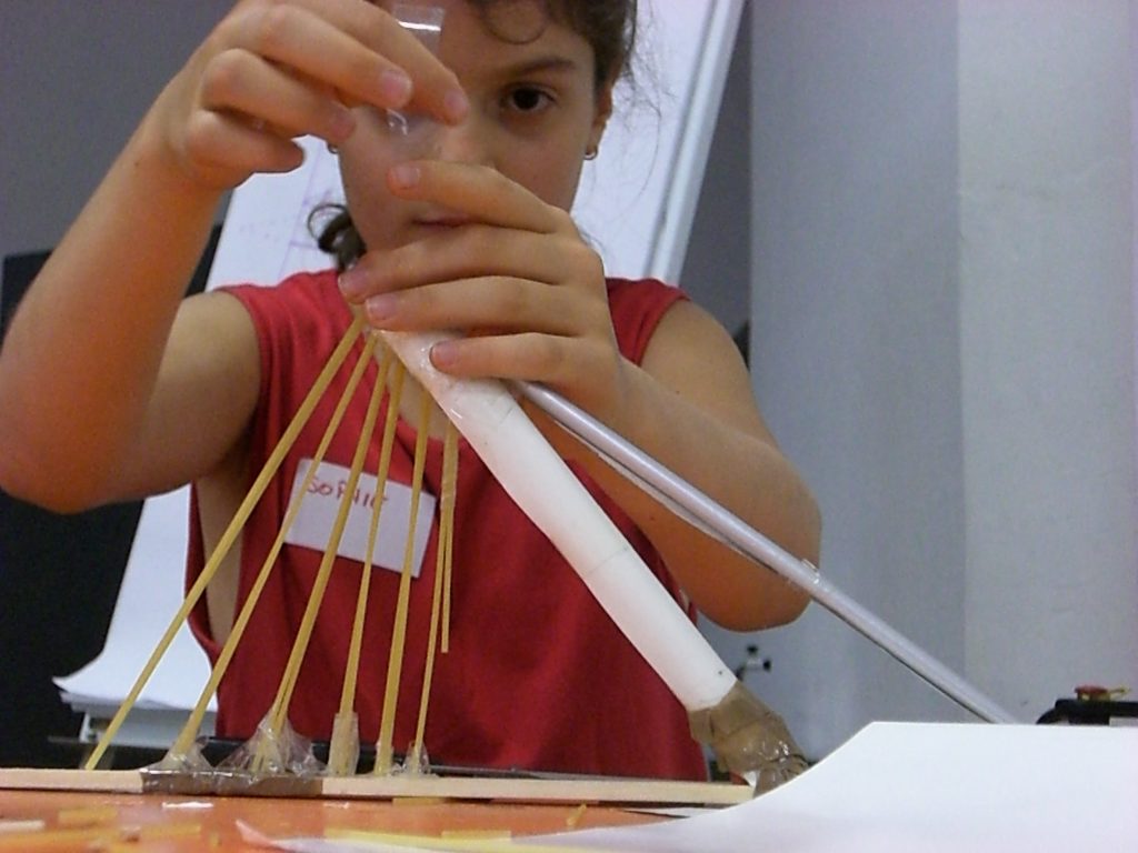 A child working on the model of a bridge.