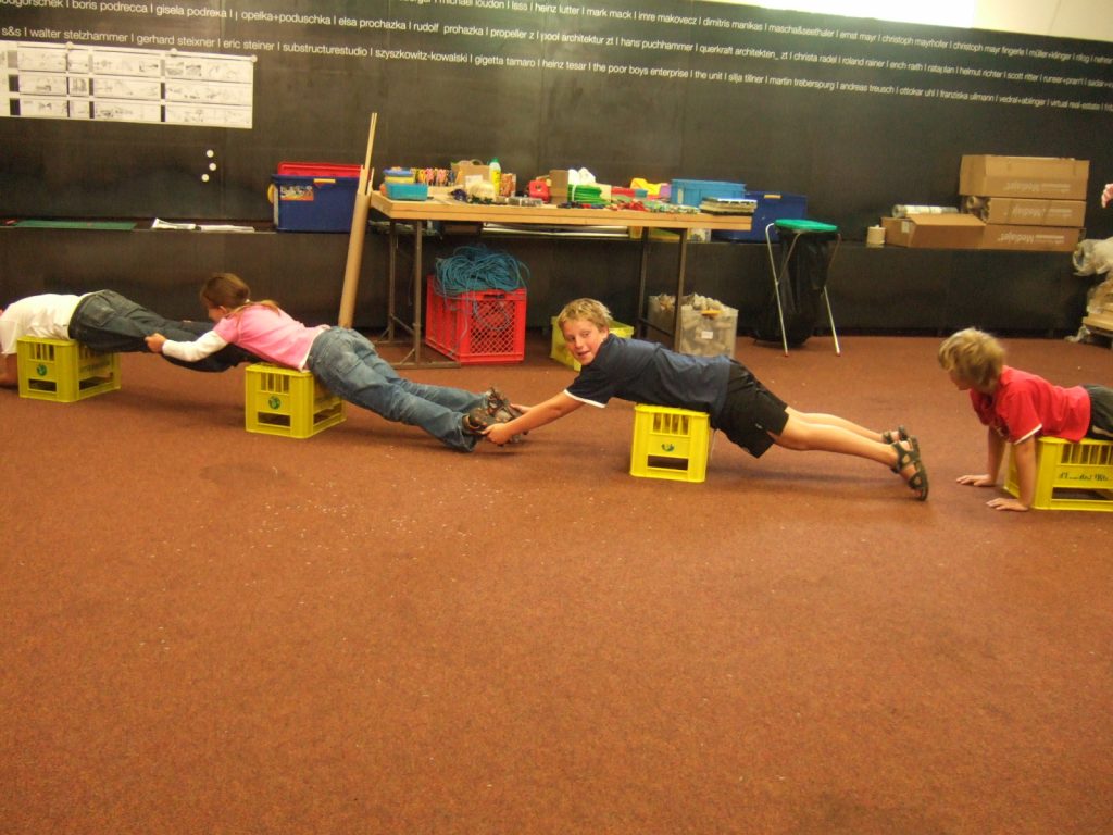Children try out the forces in a bridge with their own bodies.
