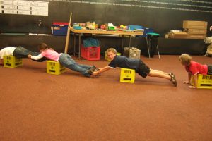 Children try out the forces in a bridge with their own bodies.