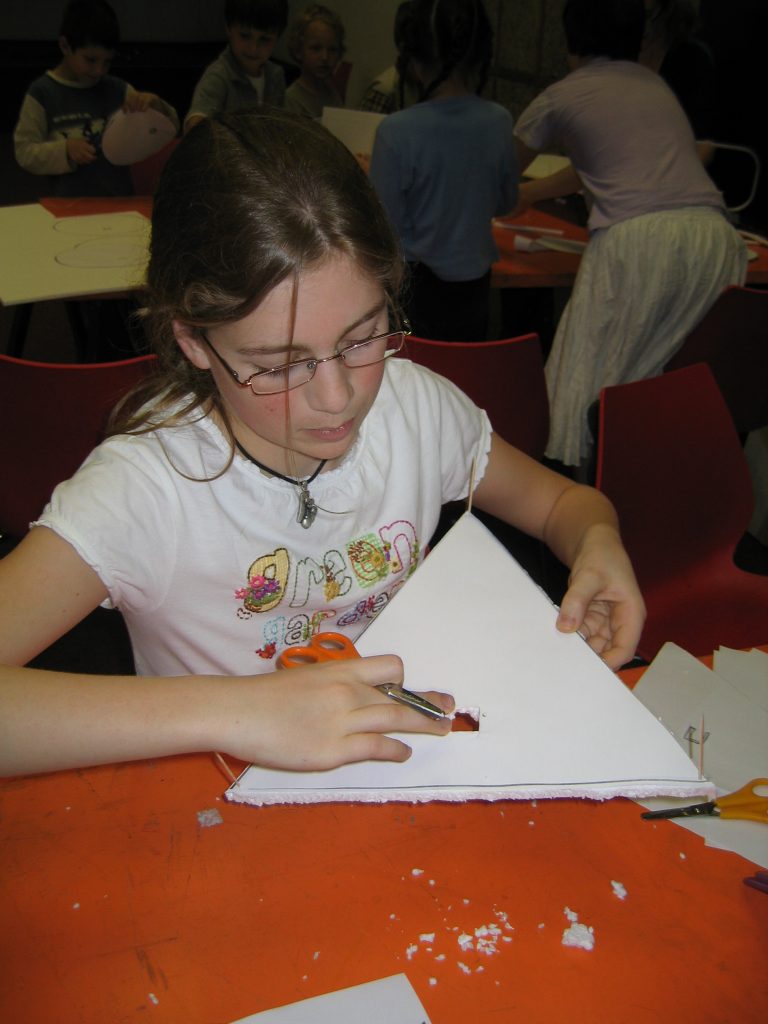 A girl holding a triangle of Styropor in her hand