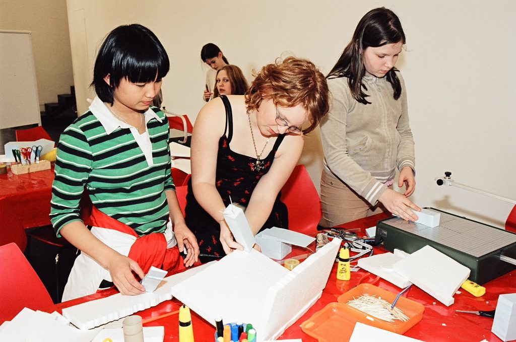 School students build a model in the workshop space.