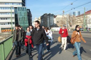 Group of school students crossing the Danube Canal, an office tower can be seen in the background.