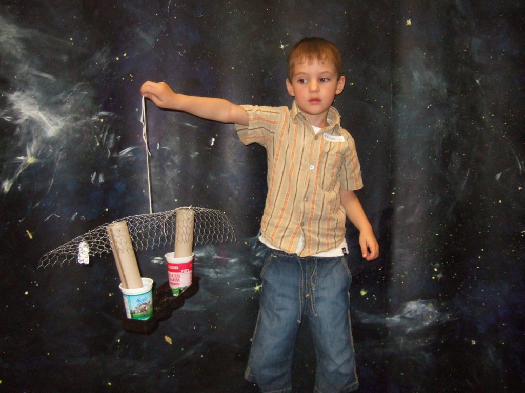 A child holding a model in his hand.