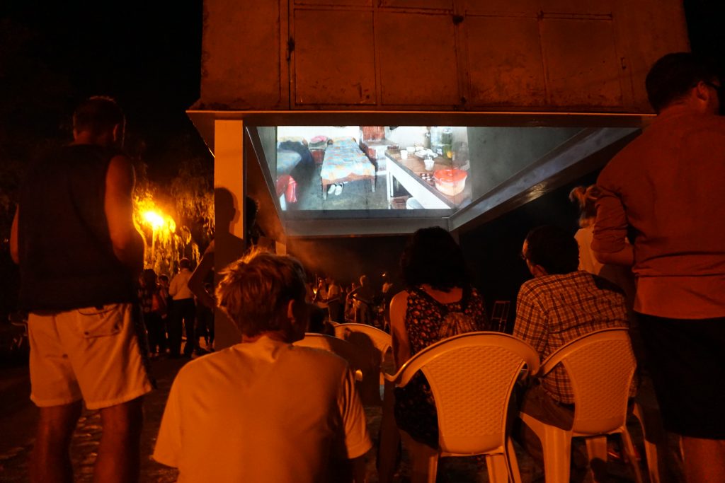 Sitzende Menschen in der Nacht, die einen Film anschauen