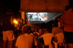 People sitting watching a film at night