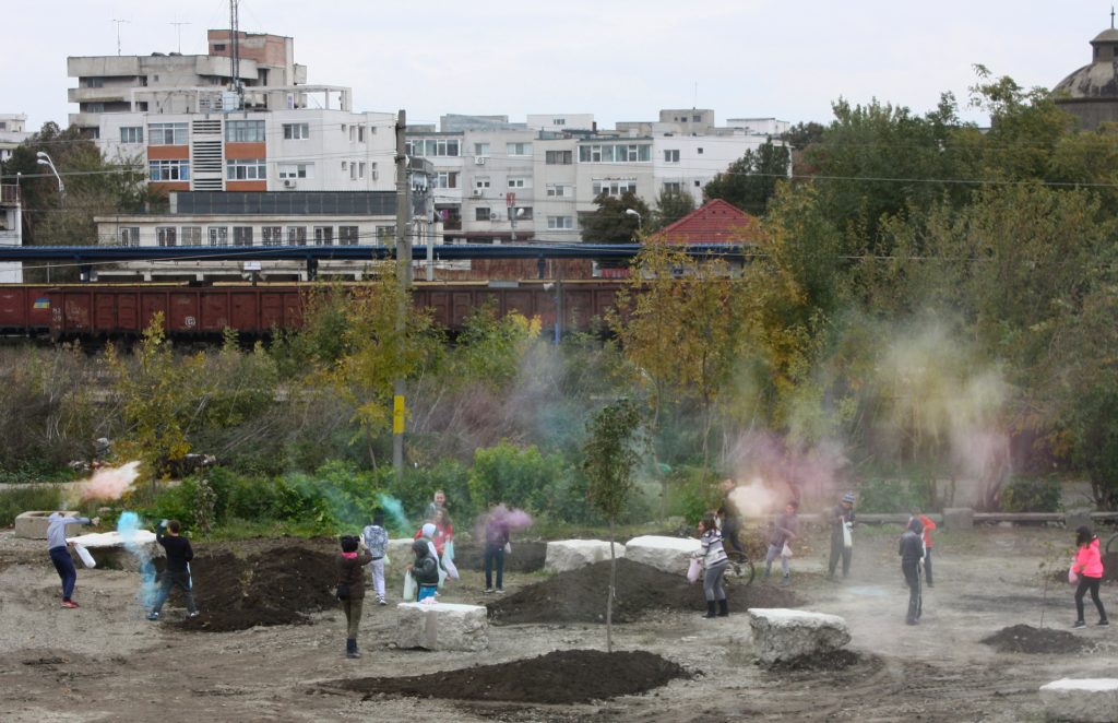 School children in a park scattering seed capsules that contain colour pigment