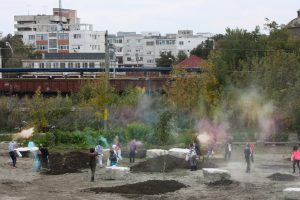 School children in a park scattering seed capsules that contain colour pigment