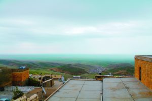 Blick von einem Gebäude auf eine hügelige Landschaft