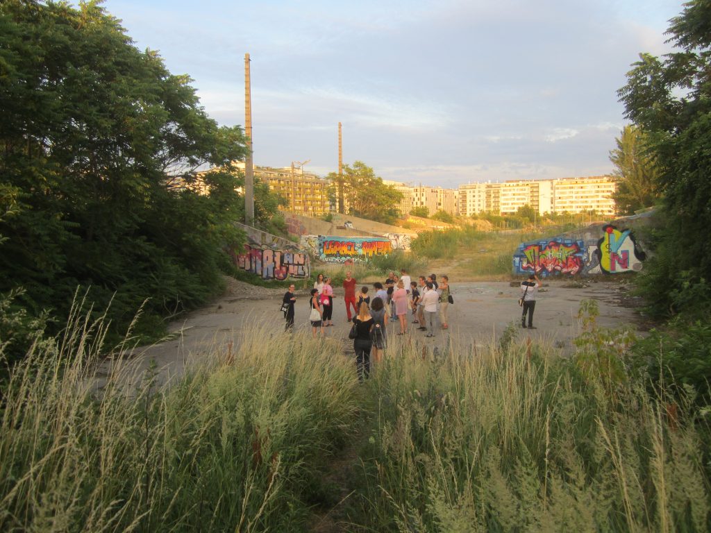 People walking through the overgrown landscape at Nordbahnhof