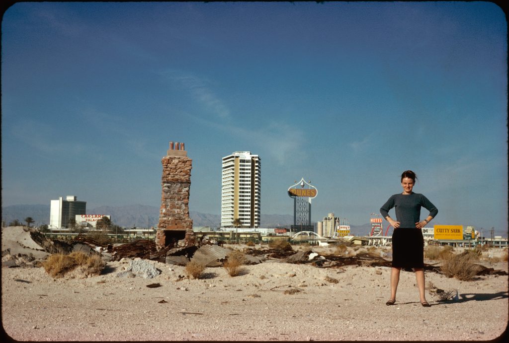 Eine Frau steht am Strand, im Hintergrund Hochhäuser