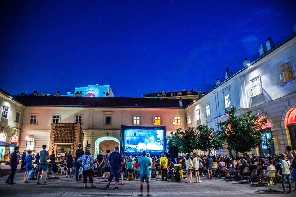 Menschen vor einer Filmleinwand