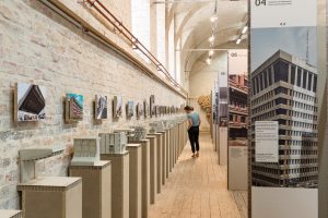 Many small concrete models and a person watching the models