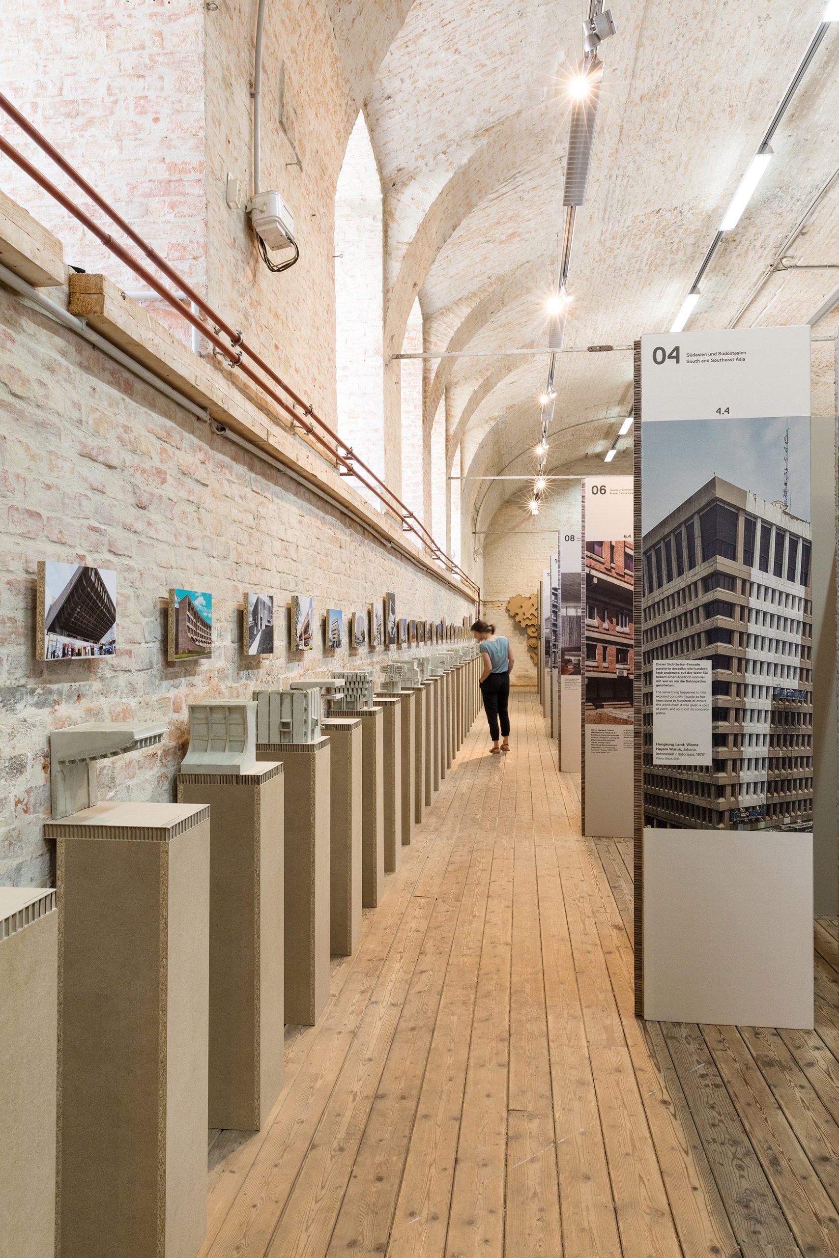 Many small concrete models and a person watching the models