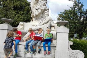 Kinder sitzen auf einem Monument