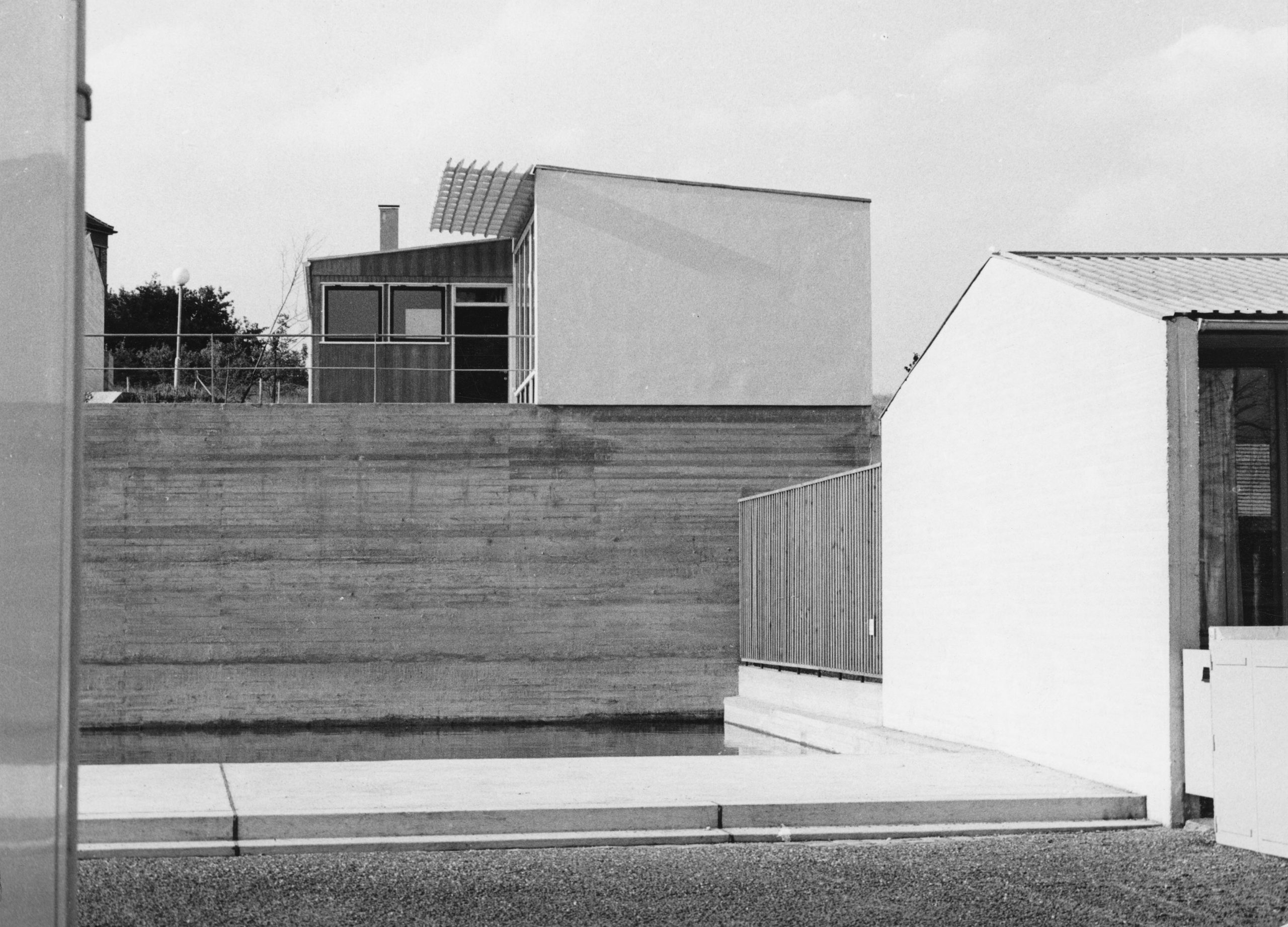 Außenansicht eines eingeschoßigen Baus mit Betonmauer