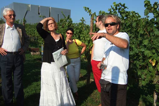 Robert Kutscha (ko a la) erklärt eine Station des Wein-Kunst-Gartens