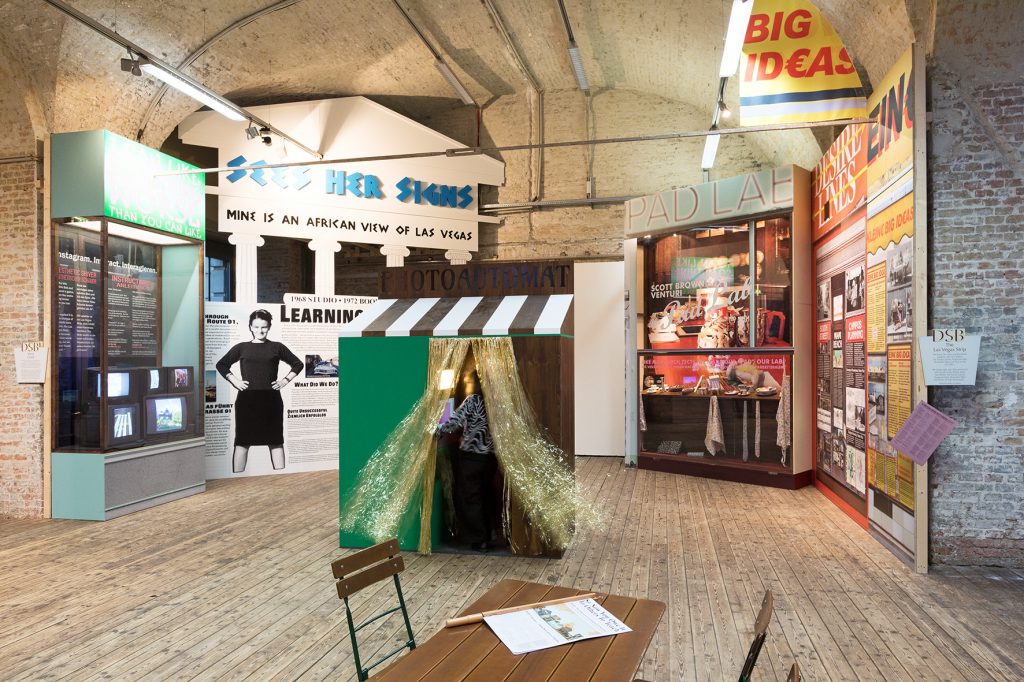 Kleine Hütte mit Glitzervorhang, im Hintergrund große Plakate