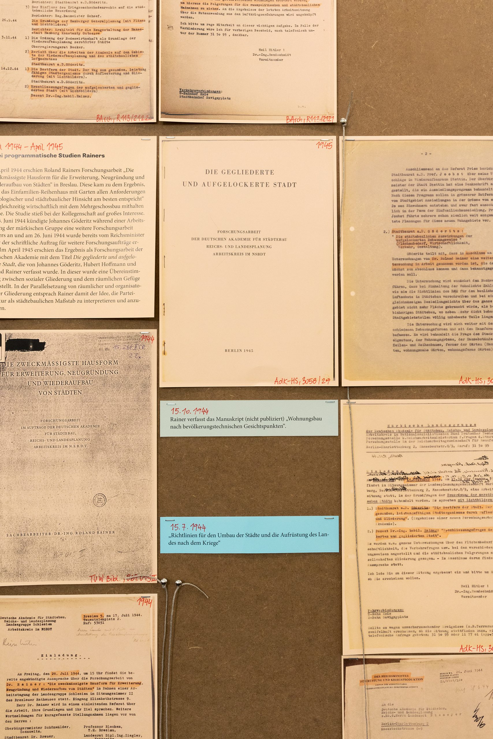 Nahaufnahme von originalen Textdokumenten, die auf einer Ausstellungstafel hängen.