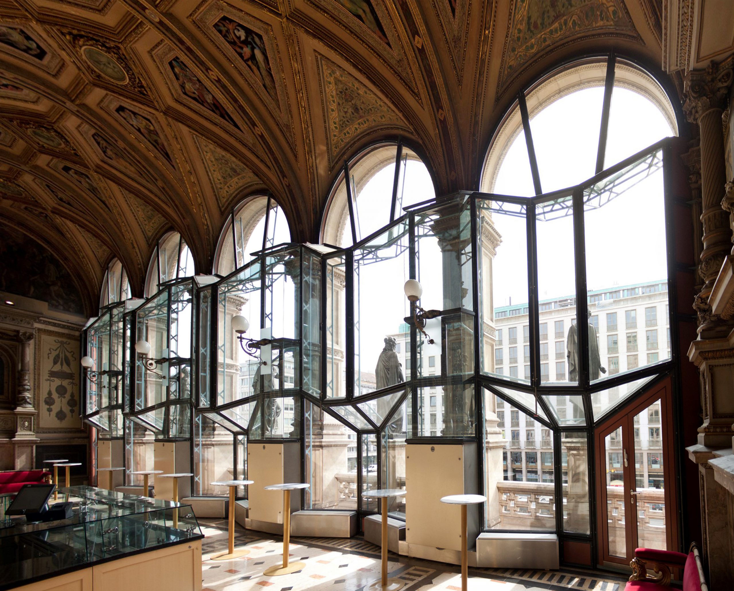 view out of large semicircular windows with sculptures in front of the windows