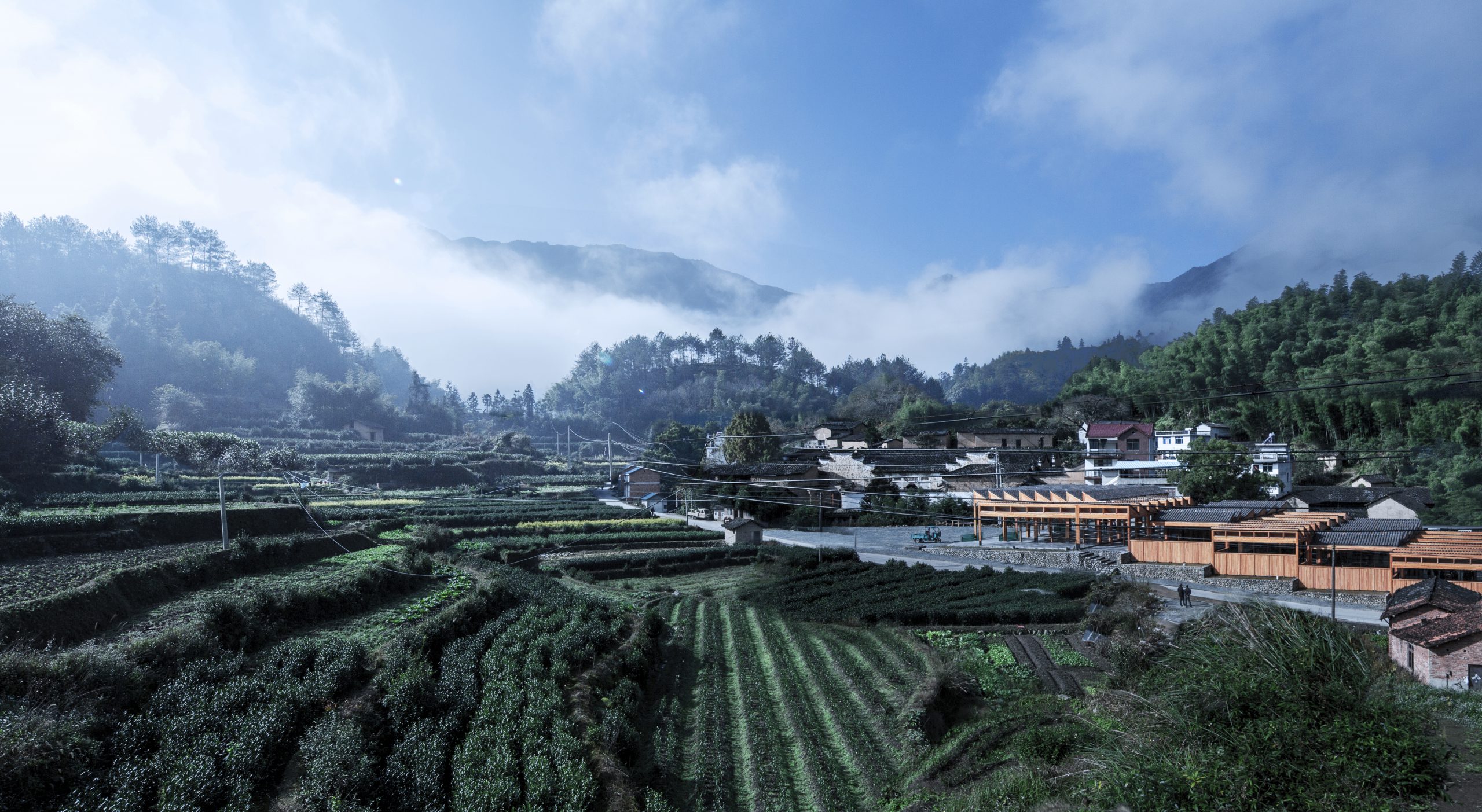 A wooden terraced building in the middle of a hilly landscape