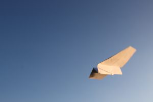 Papierflieger und blauer Himmel