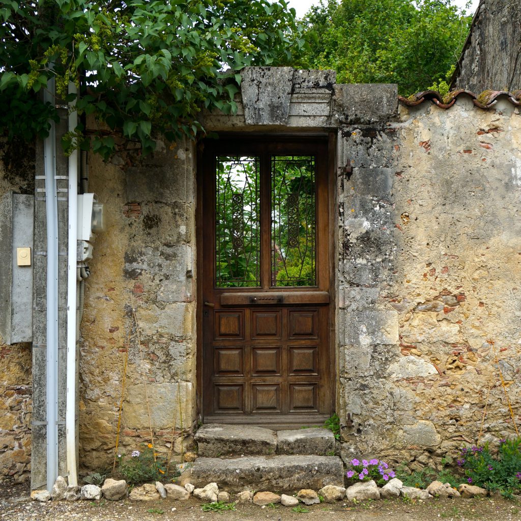 Holztüre mit Fenster in einer Mauer