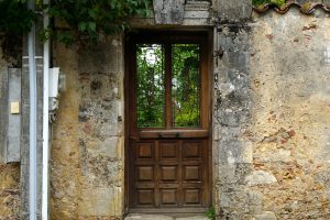 Holztüre mit Fenster in einer Mauer