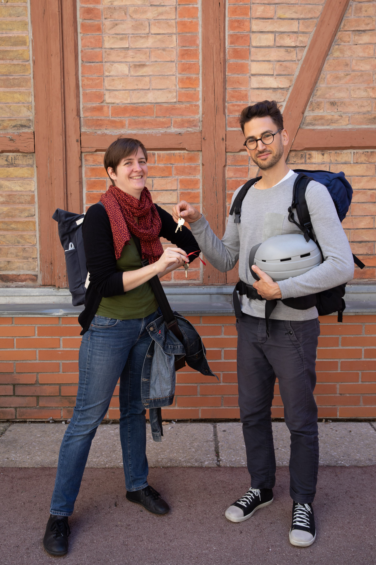 2 Personen vor Ziegelwand