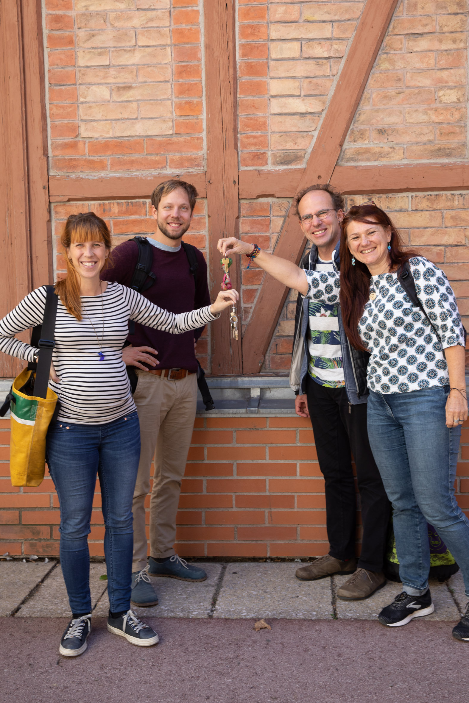 4 Personen vor Ziegelwand