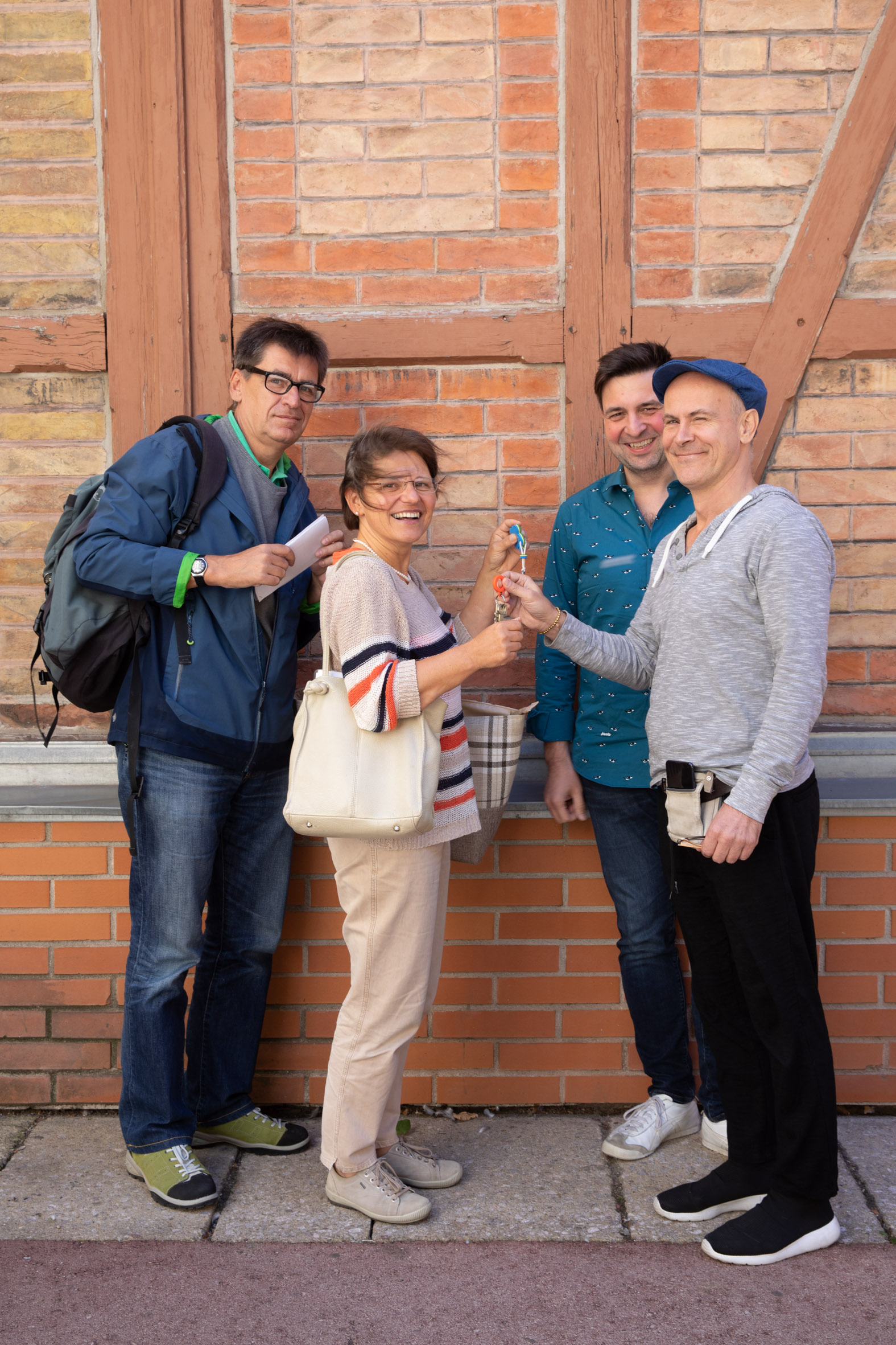 4 Personen vor Ziegelwand