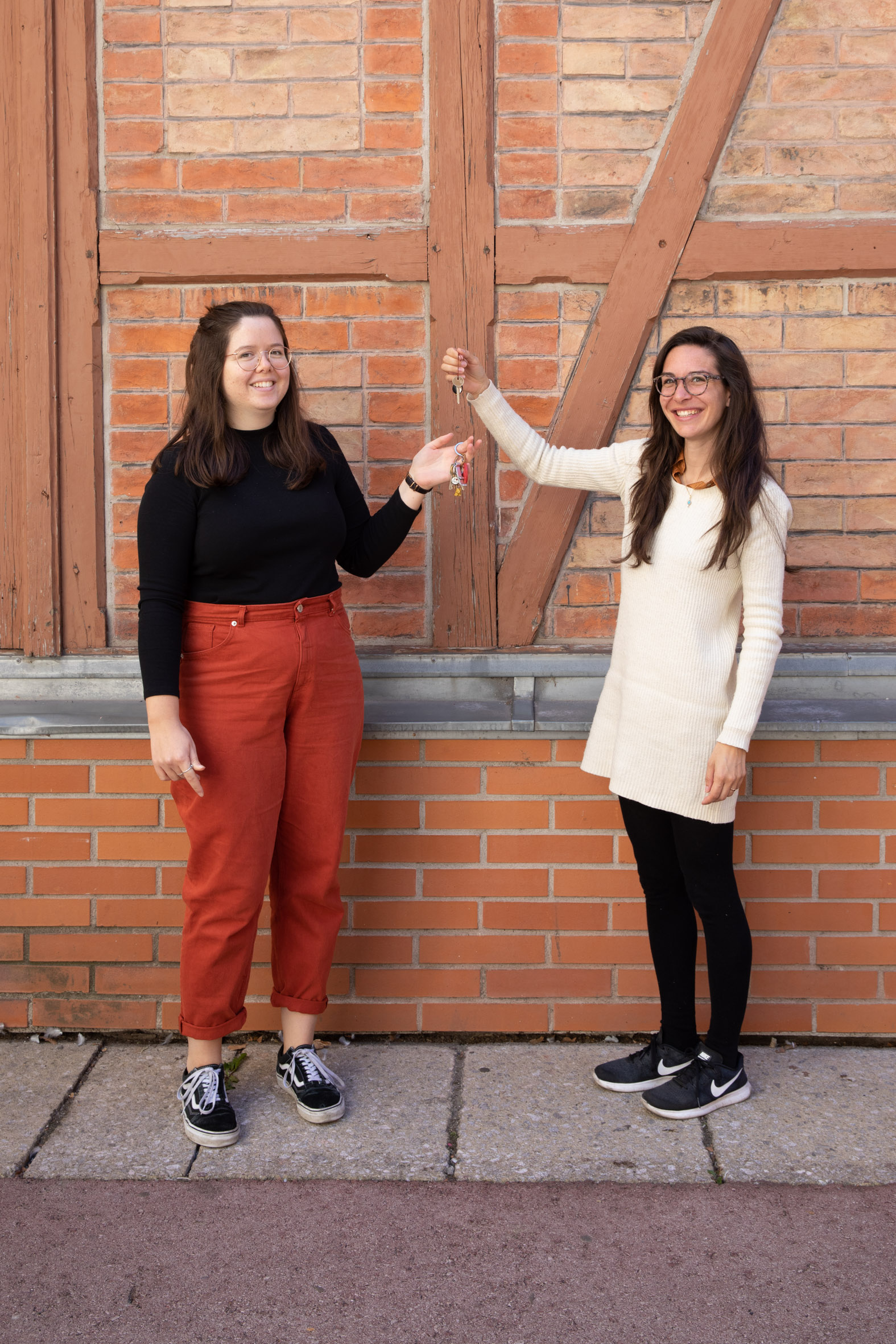 2 personen vor Ziegelwand