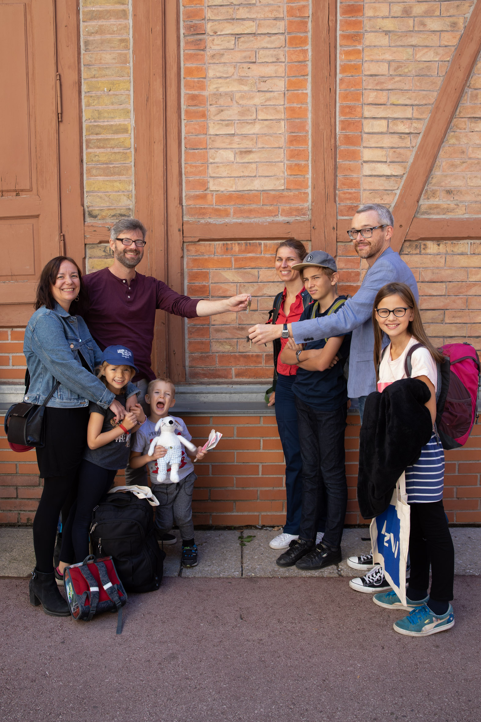 8 Personen vor Ziegelwand