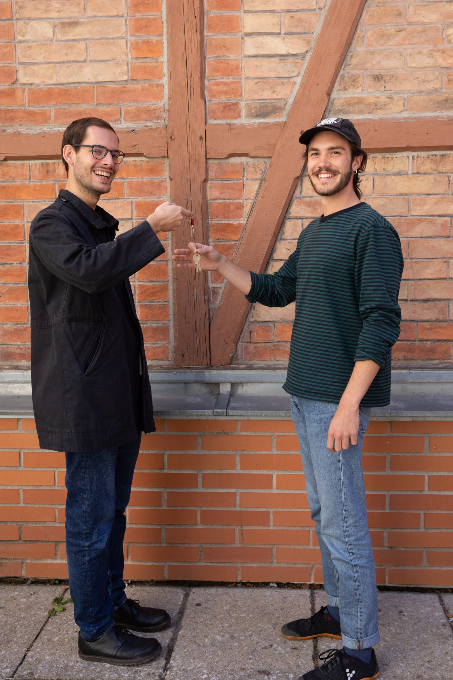 2 Personen vor Ziegelwand