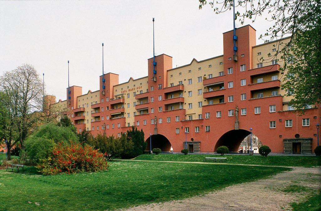 View of a multi-storey apartment block with yellow-red façade