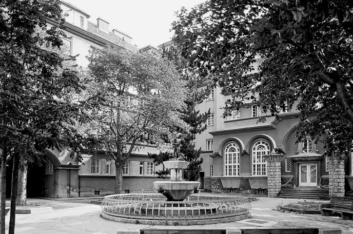 Schwarz-weiß-Foto eines Innenhofs mit Brunnen und Bäumen