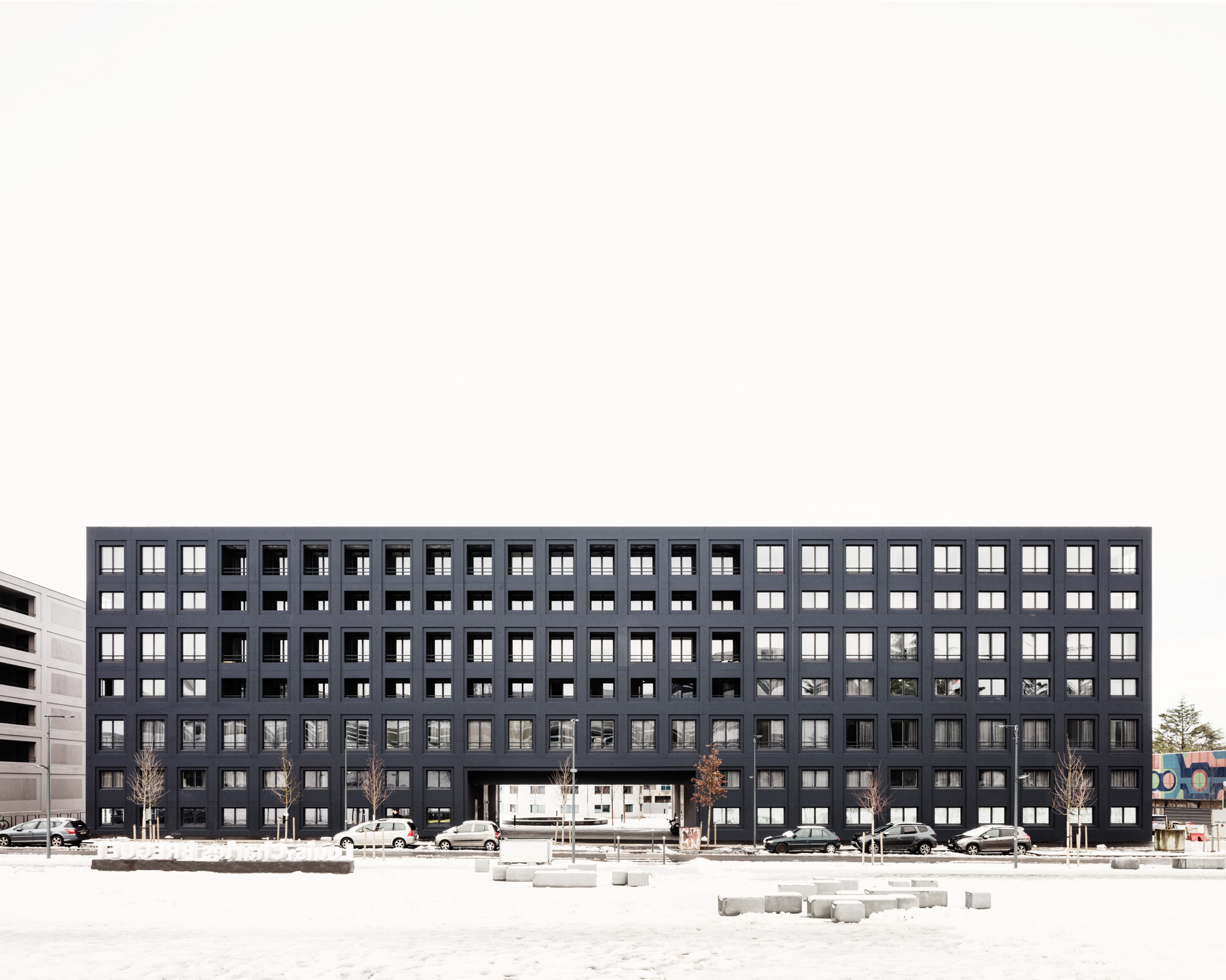 längliches dunkles Gebäude mit weißem Hintergrund