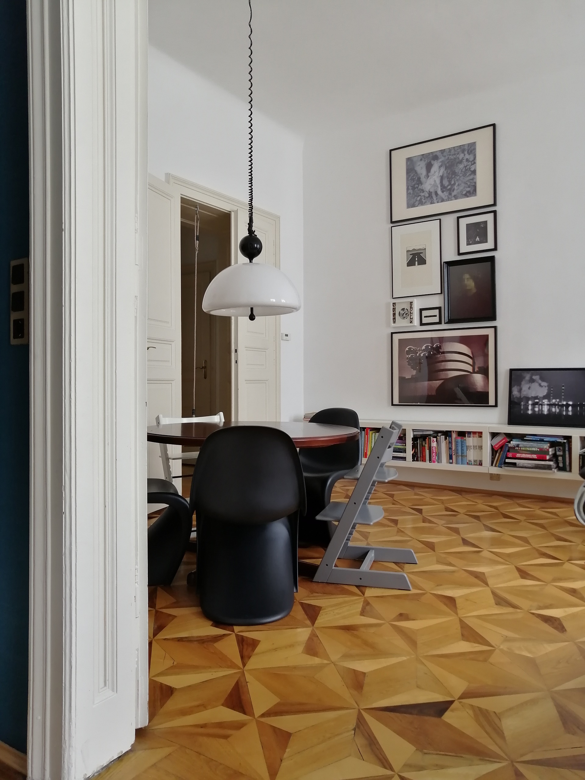 Wohnzimmer mit Tisch, Stühlen und Bildern an der Wand