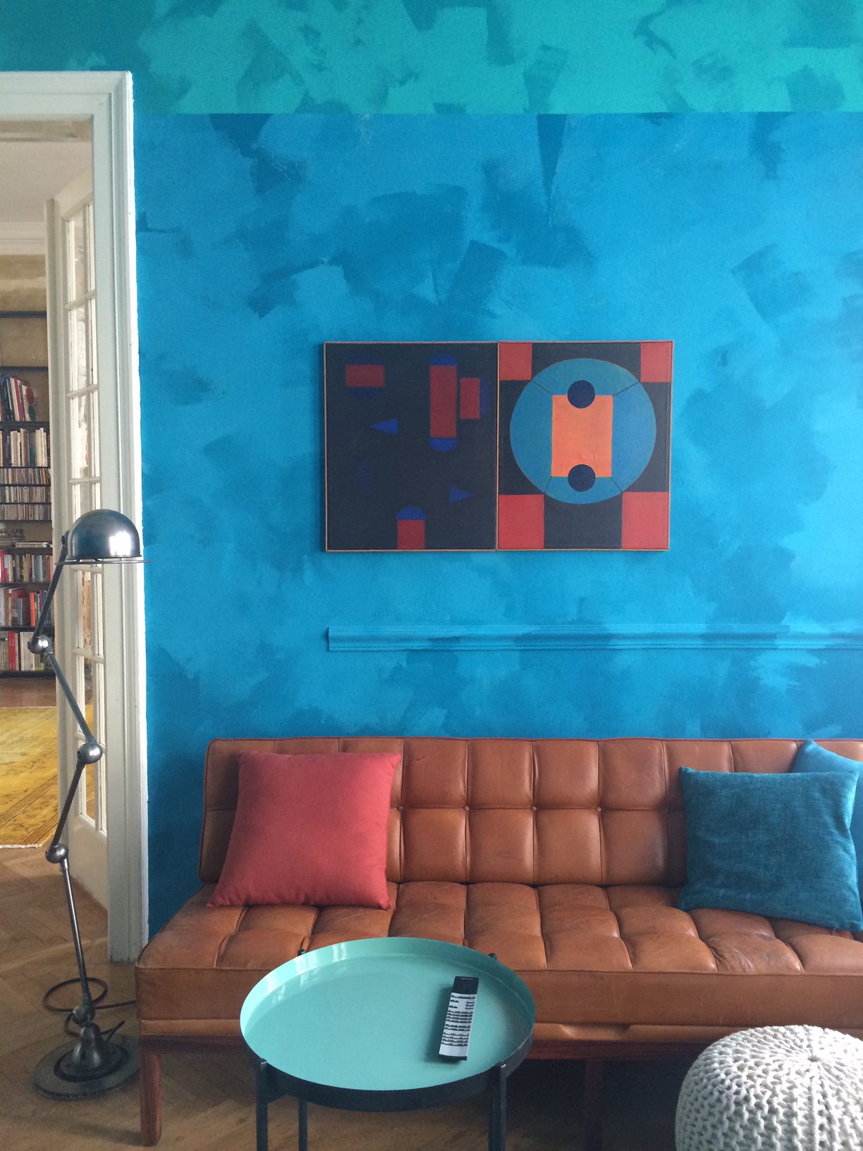 Brown couch in front of blue wall with picture