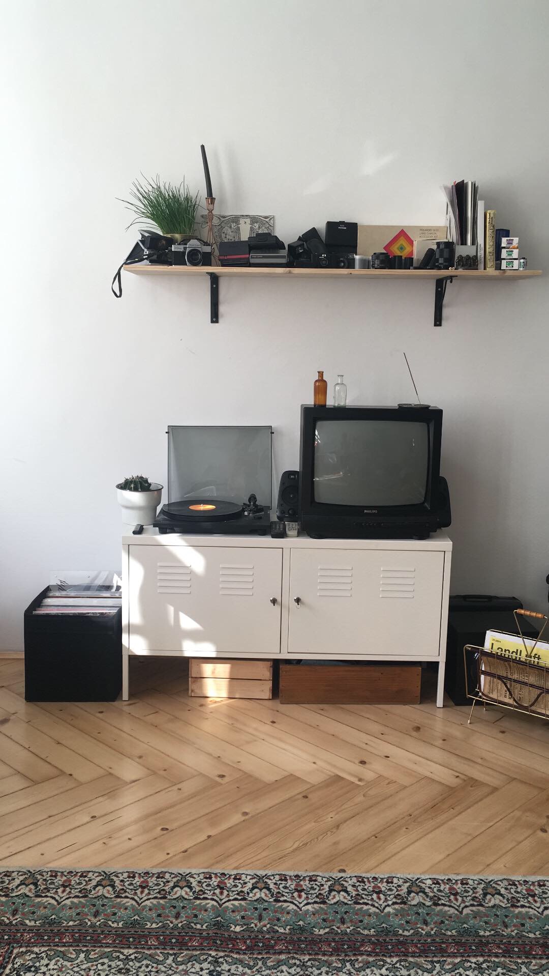 A box with television and record player on it, a shelf above it