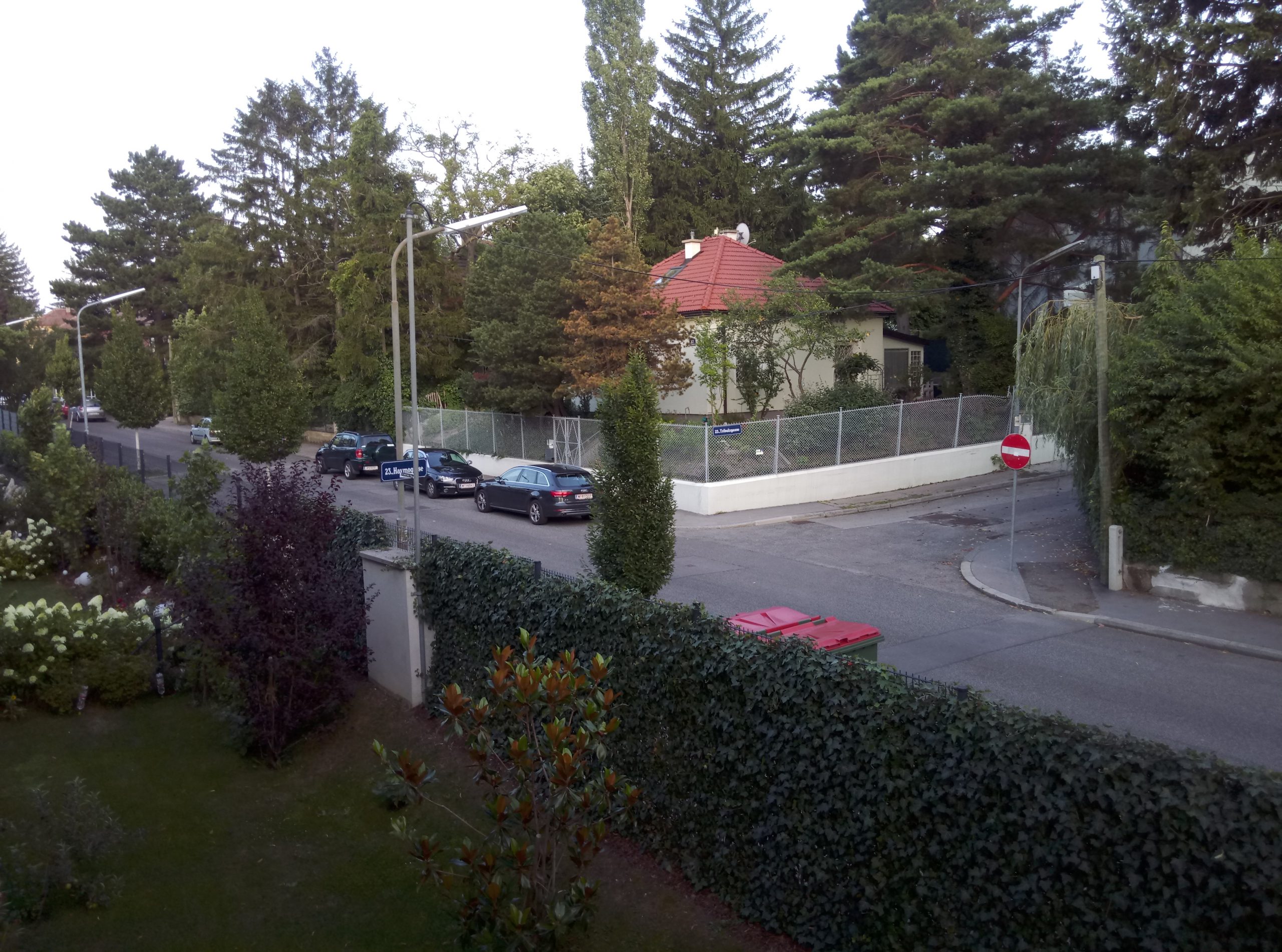 Blick auf Straßenkreuzung, davor ein Garten