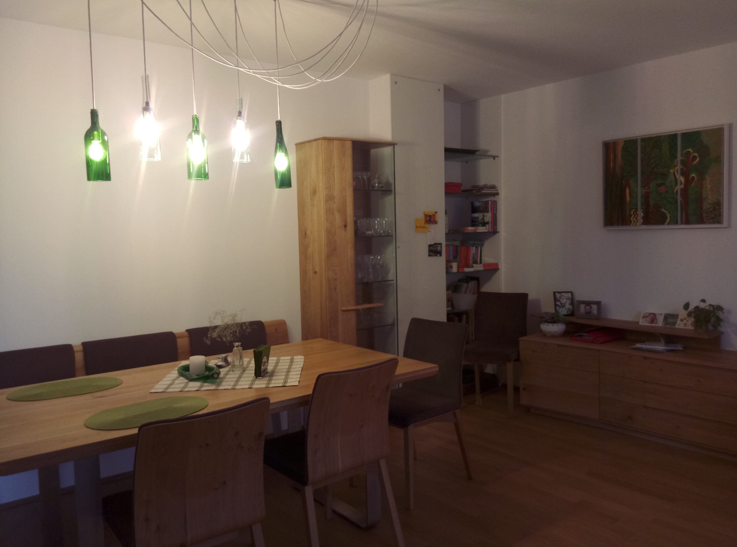 A dining table with banquet and chairs, shelves and chest of drawers