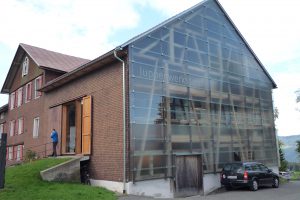 a house with shingle façade on the one hand and glass façade on the other hand